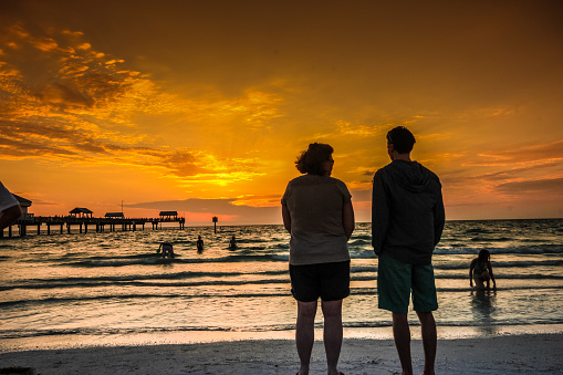 Clearwater, FL, USA - March 23, 2014: Couple enjoying sunset over Pier 60 in Clearwater beach, Florida