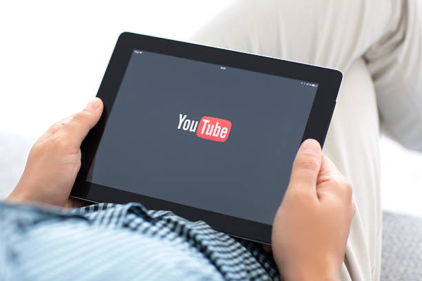 man holding iPad with app YouTube on the screen Simferopol, Russia - July 9, 2014: YouTube service that provides a video hosting service. Users can add, view, comment and share videos with friends. movie sound clips stock pictures, royalty-free photos & images