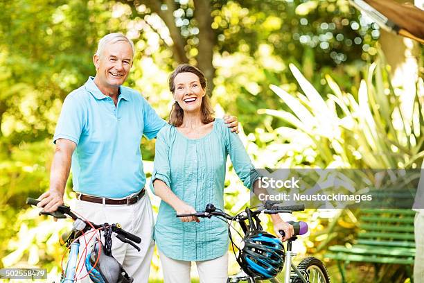 Happy Senior Mann Stehend Mit Fahrrad Auf Frau Arm Stockfoto und mehr Bilder von 60-64 Jahre - 60-64 Jahre, 60-69 Jahre, Aktiver Lebensstil