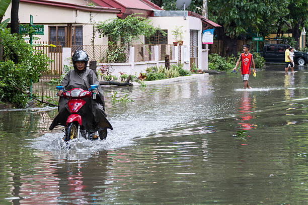 Typhoon Glenda (Rammasun) - Water Ride Antipolo, Rizal. Philippines - 16th July, 2014: A man on a motorbike makes his way through the flood in the wake of Typhoon Glenda typhoon stock pictures, royalty-free photos & images