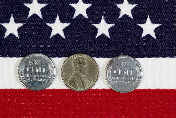 Closeup view of United States One Cent Pieces, original World War II dates, placed on American Flag