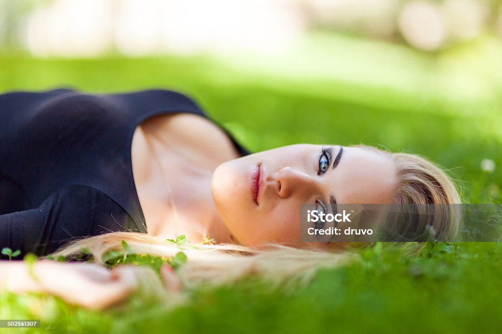 Junge Frau, die Festlegung auf dem Rasen - Lizenzfrei 20-24 Jahre Stock-Foto