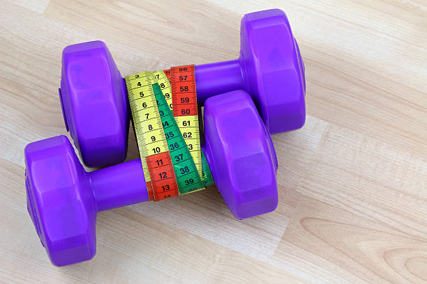 istock Purple dumbbells with a measuring tape 502565139