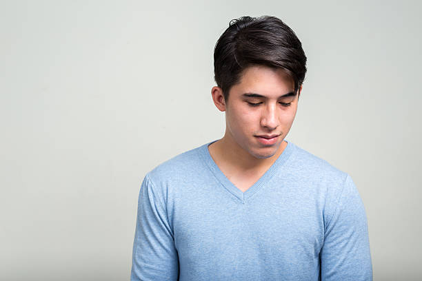 Studio shot of young man thinking while looking back horizontal shot