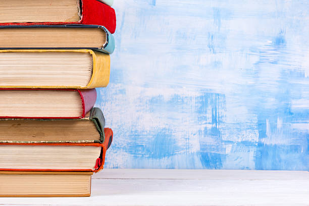 istock Stack of colorful hardback books, open book on blue background 502579656