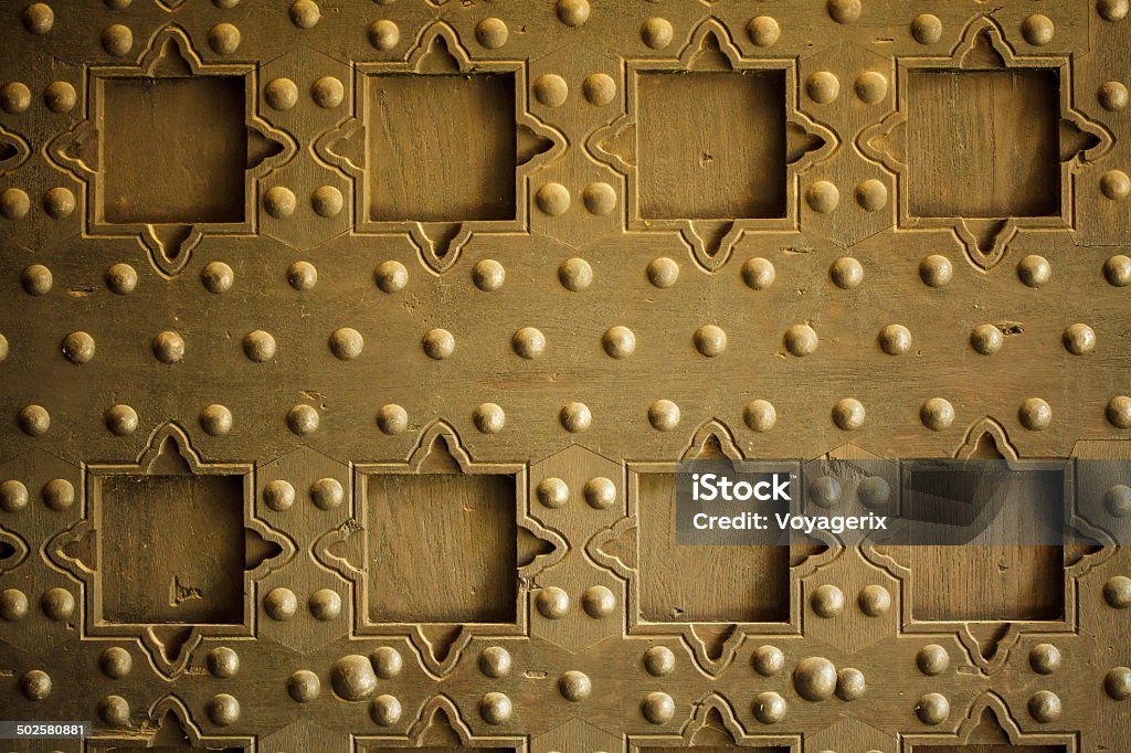 Old wooden background with metal rivets vintage door detail Vintage grunge wooden background door gate of the old castle detail with metal rivets Abstract Stock Photo