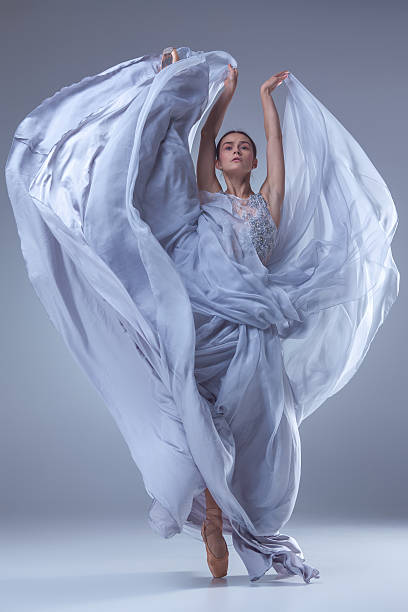 красивый ballerina танцы в синий длинное платье - beautiful glamour motion purple стоковые фото и изображения