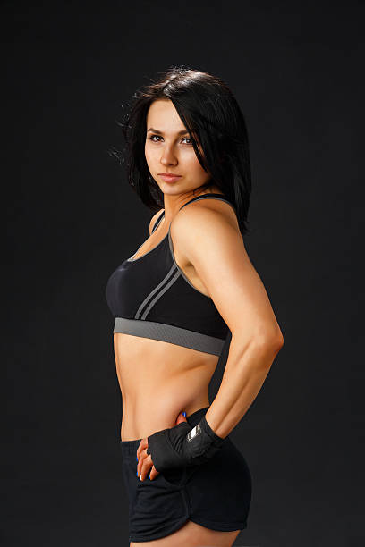 istock Young sportive woman at black background 502584458