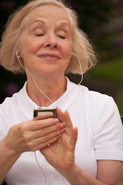 istock Senior woman listening to music using electronic device 502584503