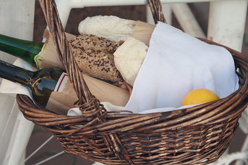 Bread, wine and lemon in a wicker basket. Food and beverages