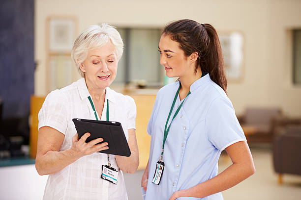 istock Female Consultant In Meeting With Nurse Using Digital Tablet 502585913
