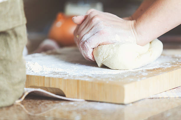 istock Women hands crumpling piece of dough on board 502603792