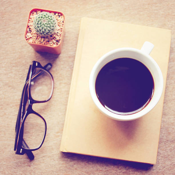 istock Black coffee on notebook and cactus with eyeglasses 502604541