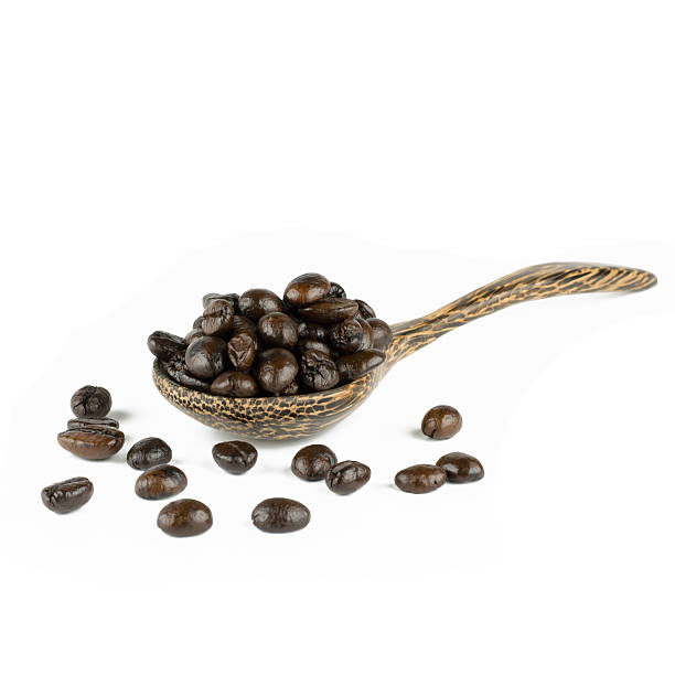 istock coffee beans in olive wood spoon, isolated on white 502604972
