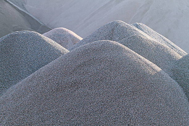 Gravel Quarry Gravel piles in a quarry shot in late afternoon sun. Shot with shallow dof to emphasize the mounds of gravel in foreground (in focus) and keeping the background out of focus. gravel mound stock pictures, royalty-free photos & images
