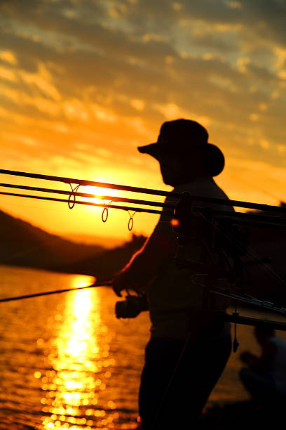 Man fishing on a lake Sunset.