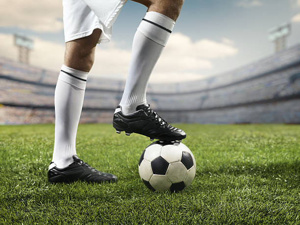 fußballer bein auf einem fußball-ball - soccer shoe soccer player kicking soccer field stock-fotos und bilder