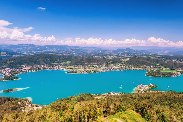 Lake Wörthersee View over the Wörthersee and the villages Maria Wörth and Pörtschach with Austrian Alps in the distance maria woerth stock pictures, royalty-free photos & images