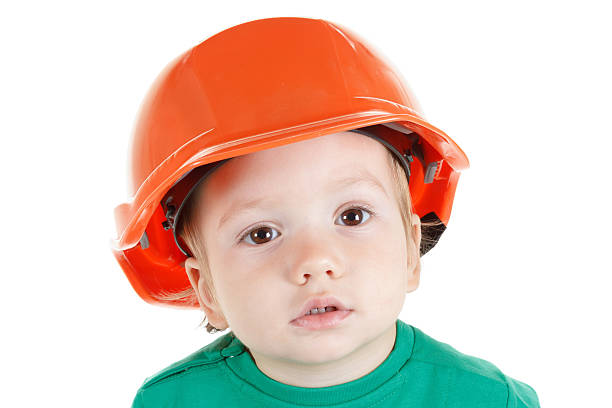 istock Little child plays with construction protective helmet  on white background. 502614302