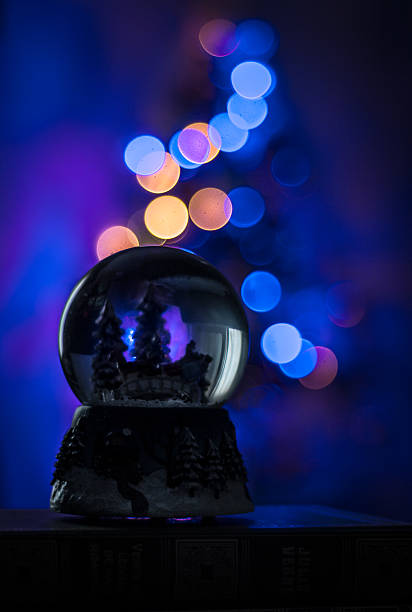 Snow globe with christmas lights on bokeh stock photo