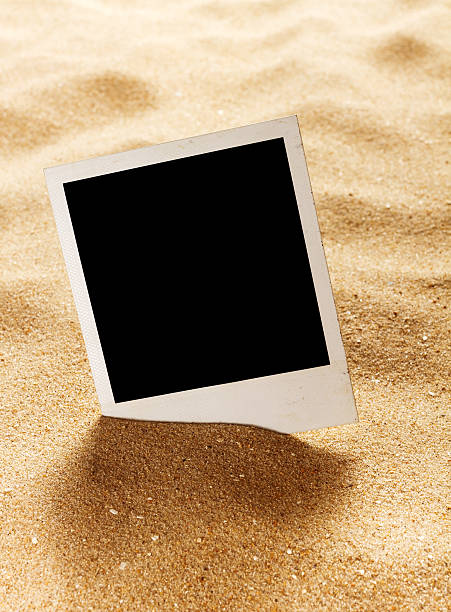 istock Old style empty photo cards on a sea sand 502620619