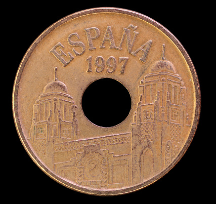 The head face of 25 pesetas coin, issued by Spain in head, obverse, 25, pesetas, spain, depicting towered buildings. Image isolated on black background