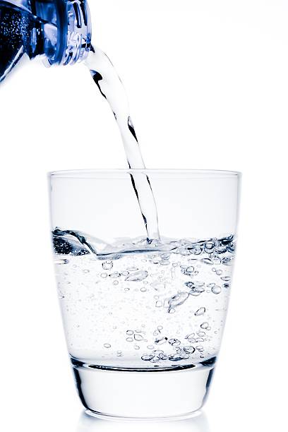 istock filling a glass with water trough blue bottle 502635724