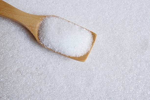 istock white sugar in wood spoon 502640360