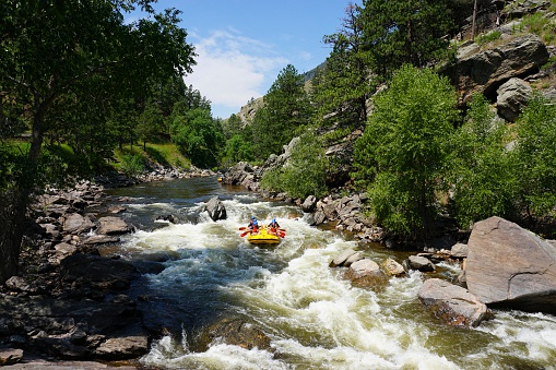 Fort Collins, Colorado, USA - July 20, 2014: A group of people enjoying white water rafting the Poudre River outside of Fort Collins, Colorado.
