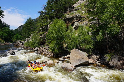 Fort Collins, Colorado, USA - July 20, 2014: A group of people enjoying white water rafting the Poudre River outside of Fort Collins, Colorado.