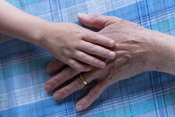 istock young child and old lady holding hands 502645109