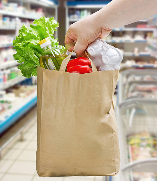 istock hand holding a paper bag with groceries 502645753