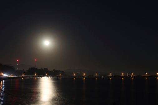 Full Moon over the Goleta Pier with reflection on the ocean.