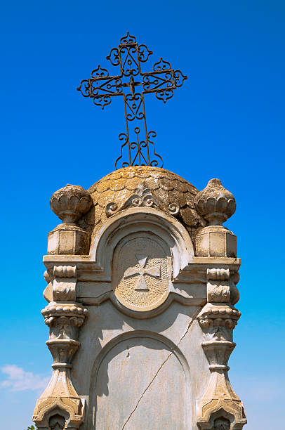 istock Cross over a gravestone on the old  cemetery. 502660215