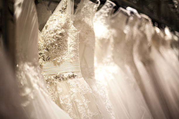 Wedding Dress Rack A shopping rack full of white wedding dresses with different styles and sizes.  wedding dress photos stock pictures, royalty-free photos & images