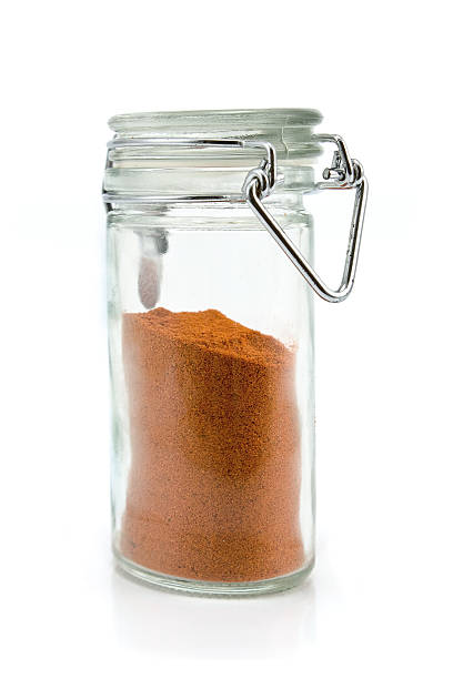 istock Red pepper powder in jar isolated on white 502660491