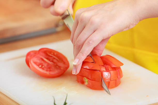 istock Woman preparing vegetables salad slicing tomato 502660682