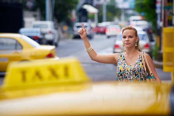 menschen reisen – business frau halten gelbe taxi - human hand waving human arm high angle view stock-fotos und bilder