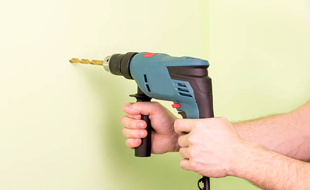 istock Holding  in hands Electric drills 502664262