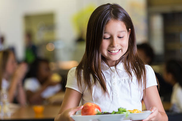 istock Cute elementary student looking at tray of cafeteria food 502666477
