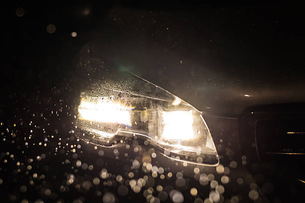 Close-up on a car headlight. Night. Rain stock photo