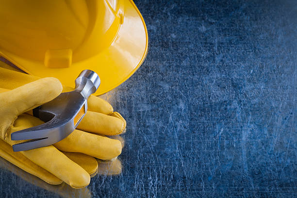 istock Leather working gloves hard hat and claw hammer on scratched 502668442