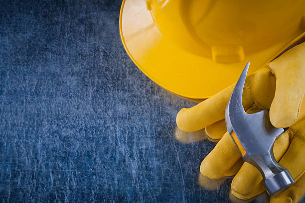 istock Pair of protective gloves hard hat and claw hammer on 502668890