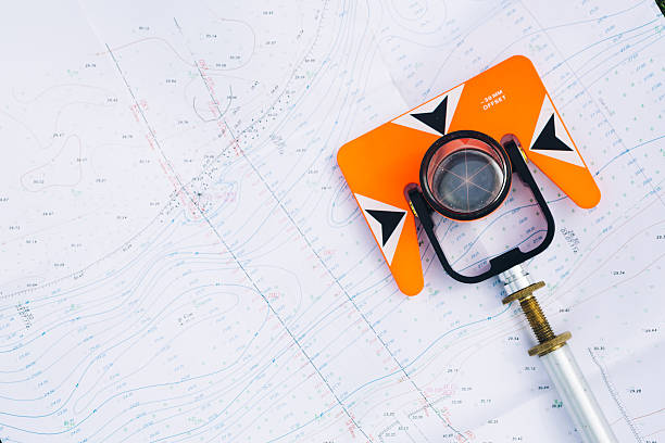 laranja teodolito prisma situa-se sobre um fundo geodésicas maps - tachymeter imagens e fotografias de stock