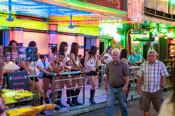 пешеходы ходьбы принял go-go бар в soi cowboy, bangkok - gogo bar стоковые фото и изображения