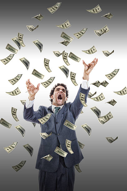 istock excited man catching money falling around him 502683333