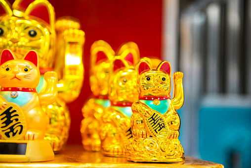 This is a horizontal, color photograph of lucky golden cats for sale in Hong Kong China.