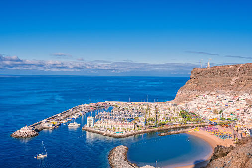 Seascape with catamaran over the harbour, town and beach of Puerto de Mogan, Gran Canaria.