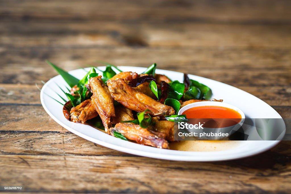 Fried Chicken with Fish Sauce Fried Chicken with Fish Sauce on wood Animal Wing Stock Photo