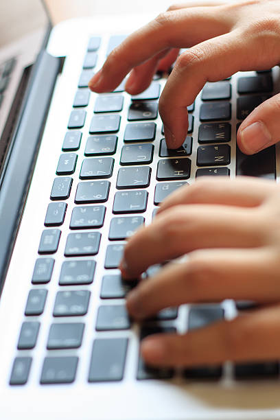 woman's hands typing on laptop keyboard